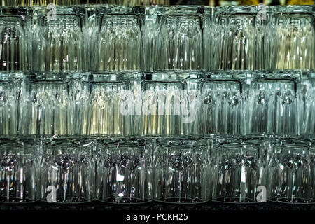 Empty glasses on bar interior background. Artificial lighting creates reflections and glares in glass. Abstract backdrop. Copy space. Stock Photo
