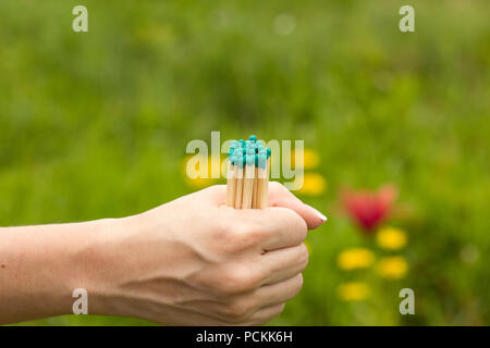 The girl holds several matches in her hand on a blurred background Stock Photo