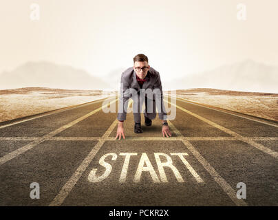 Young determined businessman kneeling before start line Stock Photo