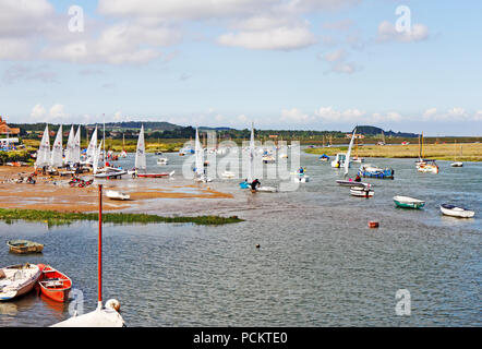 A group of sailing dinghies beaching at high water on the North Norfolk coast at Burnham Overy Staithe, Norfolk, England, United Kingdom, Europe. Stock Photo