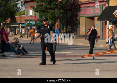 Police officers directing traffic in preparation for the annual Cruz In antique and vintage vehicle parade in downtown Montague, Michigan, USA. Stock Photo