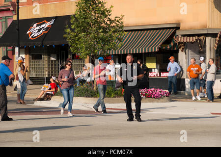 Police officers directing traffic in preparation for the annual Cruz In antique and vintage vehicle parade in downtown Montague, Michigan, USA. Stock Photo