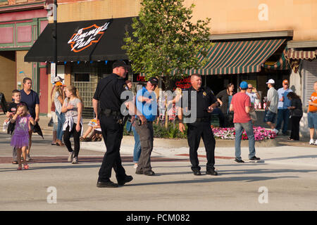 Police officers directing traffic in preparation for the annual Cruz In antique and vintage vehicle parade in downtown Montague, Michigan, USA. Stock Photo