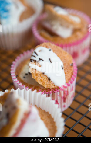 Homemade vanilla cupcakes with a chocolate coated strawberry and icing. Stock Photo