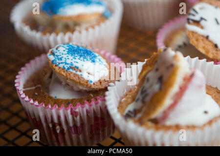 Homemade vanilla cupcakes with a chocolate coated strawberry and icing. Stock Photo
