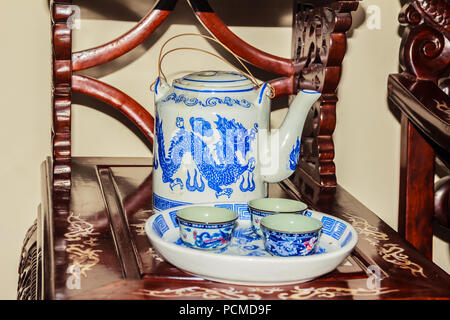 Vintage collection of blue dragon pattern on porcelain tea set with teapot and teacups. Classic old blue dragon pattern porcelain tea set in tea shop. Stock Photo