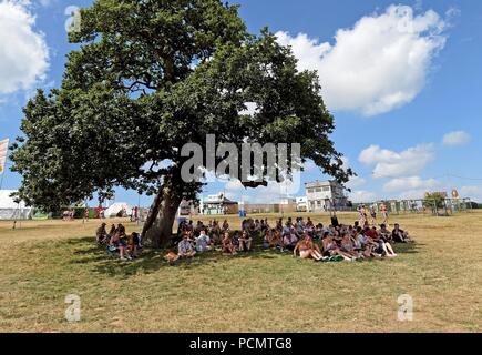 Lulworth Castle, Dorset, UK. 3rd Aug 2018. Festival goers relax in the shade at Bestival, Lulworth Castle, Dorset. Credit: Finnbarr Webster/Alamy Live News Stock Photo