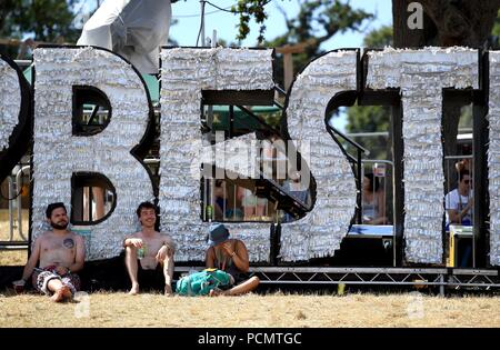 Lulworth Castle, Dorset, UK. 3rd Aug 2018. Festival goers relax in the shade at Bestival, Lulworth Castle, Dorset. Credit: Finnbarr Webster/Alamy Live News Stock Photo