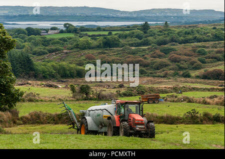 Ballydehob, West Cork, Ireland. 3rd Aug, 2018. With Roaring Water Bay in the background, a Durrus based farmer sprays slurry on his field on an overcast but warm day. The heatwave is due to return this weekend, changing to rain at the start of next week. Credit: Andy Gibson/Alamy Live News. Stock Photo