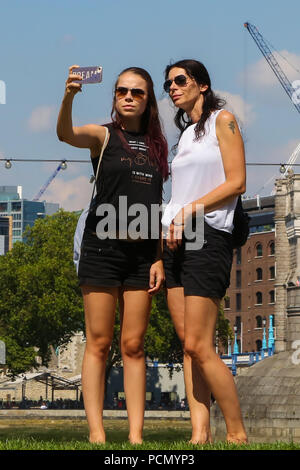 Potters Fields Park. London. UK 3 Aug 2018 - Tourists poses for a selfie on Potters Fields Park on another very hot day in the capital. According to the Met Office the heatwave is to continues in the UK and parts of Europe in coming days with record temperatures expected.  Credit: Dinendra Haria/Alamy Live News Stock Photo