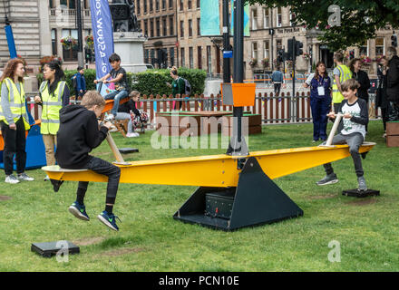 George Square; Glasgow; Scotland. 03rd August 2018. Children playing on an interactive installation named Pivot, see-saws using AI to chat with users, in George Square in the centre of Glasgow relaxing and enjoying Festival 2018. The festival is running in parallel with the European Championships; Glasgow 2018. George Square is a free venue with several live and virtual attractions daily. Credit: Elizabeth Leyden/Alamy Live News Stock Photo