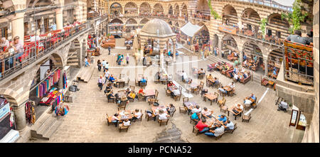 Unidentified people have breakfast and sit courtyard of Hasan Pasha Khan,a medieval inn used for cafes and small shops now in Diyarbakir,Turkey.16 Jul Stock Photo