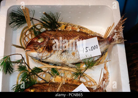 Kuromon Ichiba, Osaka's kitchen food market. Sea beam with price label for 15,000 yen in polystyrene plastic box on seafood market stall. Stock Photo