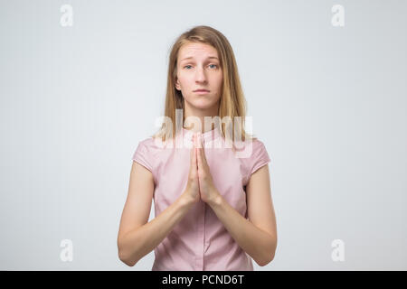 Closeup portrait of a sad young woman praying, hoping, begging for the best isolated on white background Stock Photo