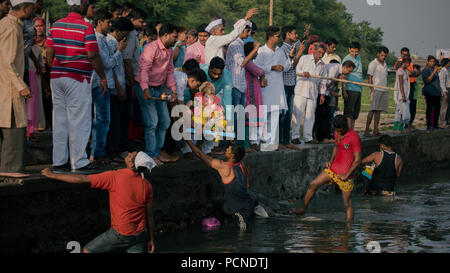 Idols of Ganesh are immersed in the Mula Mutha river at the Ganesh Chaturthi celebrations in Pune Stock Photo