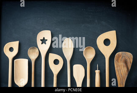 Wooden kitchen tools in a row on a chalkboard Stock Photo