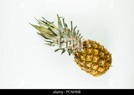 One whole pineapple on isolated white background. Top view of ripe fresh pineapple laying on white table Stock Photo