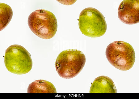 Isolated mango pattern or wallpaper on white background. Summer concept of fresh ripe whole mango fruits shot from above Stock Photo