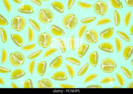 Isolated lime pattern or wallpaper on turquoise green background. Summer concept of fresh ripe lime liths and slices shot from above Stock Photo