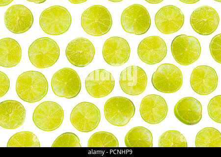 Isolated lime pattern or wallpaper on white background. Summer concept of fresh ripe lime liths and slices shot from above Stock Photo