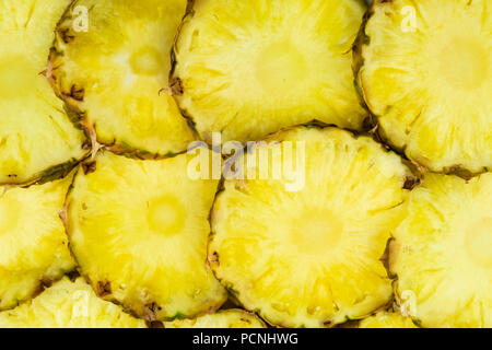 Sliced pineapple pieces lay in pattern, top view. Freshly cut pineapple fruit lay closely on each other Stock Photo