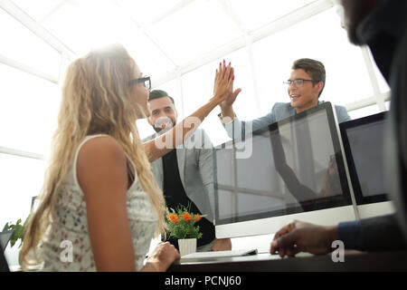young employees giving each other high five Stock Photo