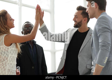 cheerful company employees giving each other high five Stock Photo