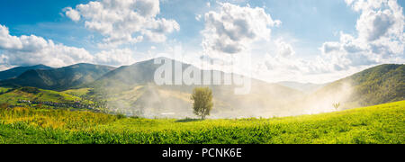 panorama of beautiful mountainous countryside. tree on the hill side in smoke from fire in the valley. wonderful bright autumn landscape with gorgeous Stock Photo