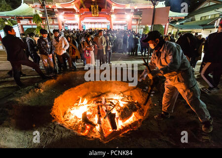 Shogatsu, new year, Nishinomiya shrine, Japan. People standing around bonfire used to burn old good luck charms, during their first visit, Hatsumode. Stock Photo