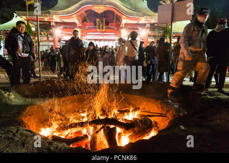 Shogatsu, new year, Nishinomiya shrine, Japan. People standing around bonfire used to burn old good luck charms, during their first visit, Hatsumode. Stock Photo