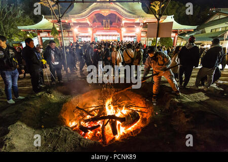 Shogatsu, new year, Nishinomiya shrine, Japan. People standing around bonfire used to burn old good luck charms, during their first visit, Hatsumode. Stock Photo