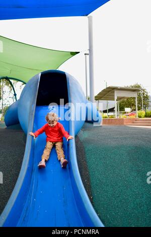 A child goes down a blue slide designed like a dugong, Cardwell, Queensland, Australia Stock Photo