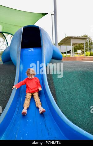 A child goes down a blue slide designed like a dugong, Cardwell, Queensland, Australia Stock Photo