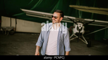 Handsome young pilot checking ultralight airplane before flight Stock Photo