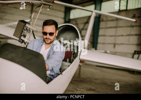 Handsome young pilot checking ultralight airplane before flight Stock Photo