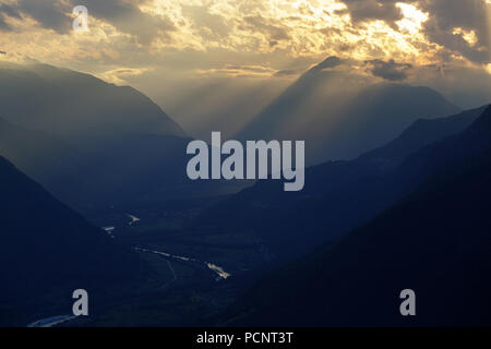 grass covered meadow at golden light, sunset on a mountain with a beautiful view over the valley with soca river and the mountains Stock Photo