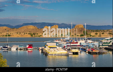 PUEBLO, CO, USA-16 JULY 18: Colorful boats in foreground, rock formations in midground, a distant mountan range, and wispy clouds above. Stock Photo