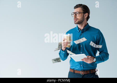 cash falling around young man with paper cup of coffee and tablet isolated on white Stock Photo