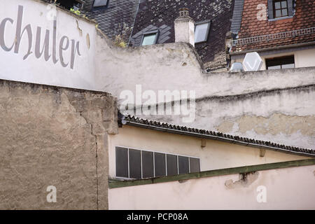 Nostalgic walls as well as new and old roofs in a backyard. Stock Photo