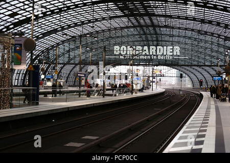 A platform of Berlin's central station with travellers and a distinctive roof construction in Berlin. Stock Photo