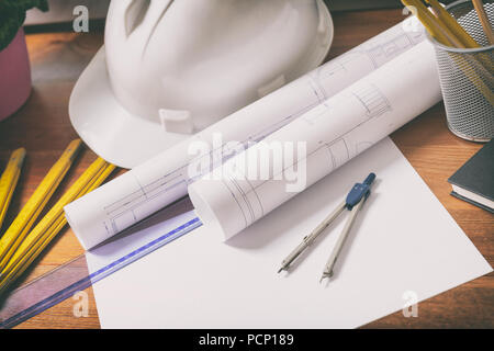 Construction plans with helmet and drawing tools on blueprints and measure Stock Photo