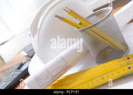 Construction plans with helmet and drawing tools on blueprints with calculator in a background Stock Photo