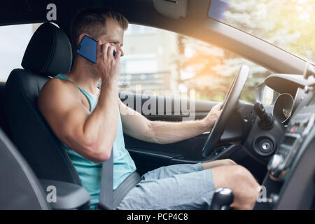 Careless driver using his mobile phone whilst driving a car Stock Photo