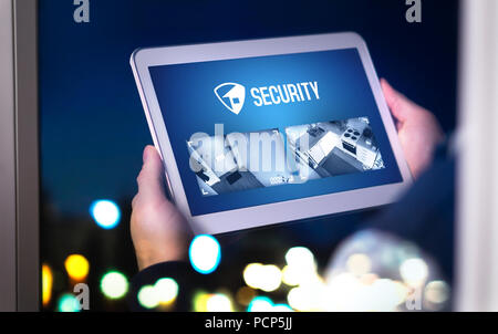 Home security system and application in tablet. Man watching protection camera live footage inside a house or apartment late at night. Stock Photo