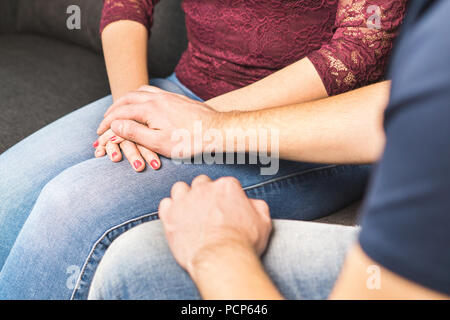 Boyfriend apologize to girlfriend. Couple support each other. Comforting or telling bad news. Young man holding hand and comforting woman. Stock Photo