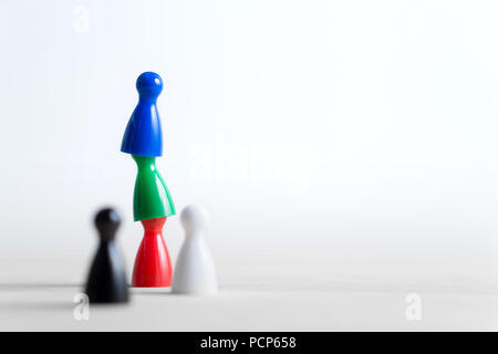 Teamwork, reaching goals, working together and success concept. Cooperation, leadership, achievement and support. Colorful board game pawns. Stock Photo