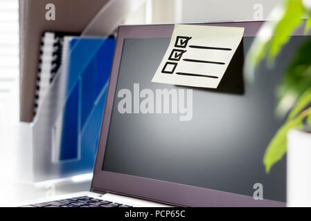 To do list in office. Planning and organizing concept. Checklist of tasks and agenda for work day. Sticky paper and note on laptop. Stock Photo