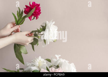 Woman florist making a bouquet of peonies. At work. Copy space. Stock Photo