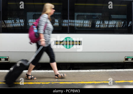 A passenger walking past a Southern Railway carriage at Brighton train station in England. Stock Photo