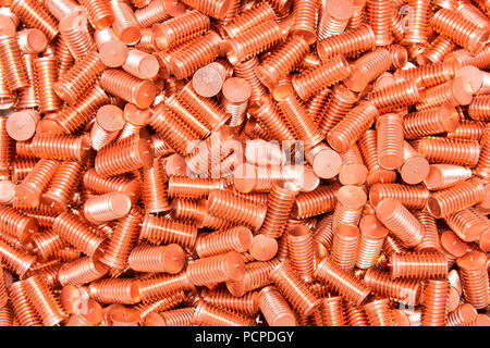 Pile of threaded copper metal screw bolts Stock Photo